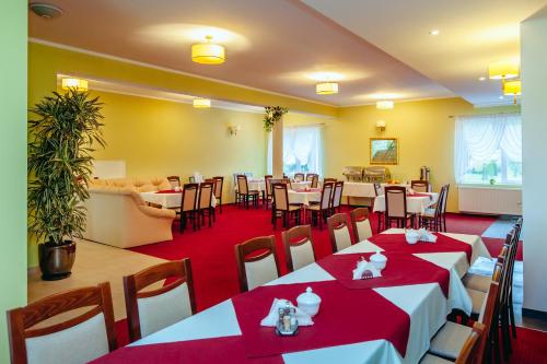 um restaurante com mesas e cadeiras num quarto em Morski Raj em Sarbinowo