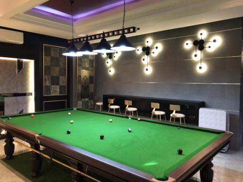 a room with a pool table and chairs at Qu Lin Resident in Sibu