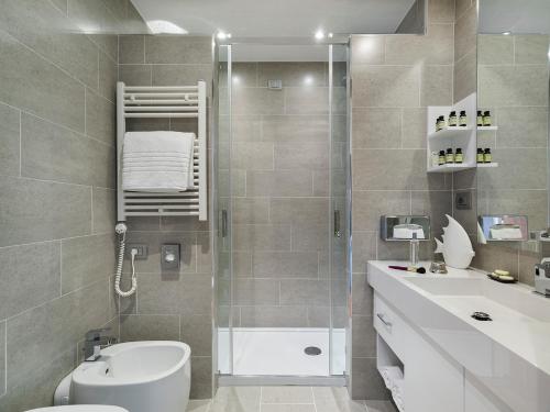 a bathroom with a shower and a toilet and a sink at Grand Hotel Pietra Ligure in Pietra Ligure