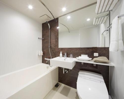 un baño con inodoro y lavabo en Iroha Grand Hotel Matsumoto Eki-Mae, en Matsumoto