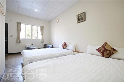 two beds in a room with white walls at Double Lake B&B in Zhushan