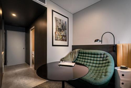 a living room with a green couch and a table at Veriu Green Square in Sydney