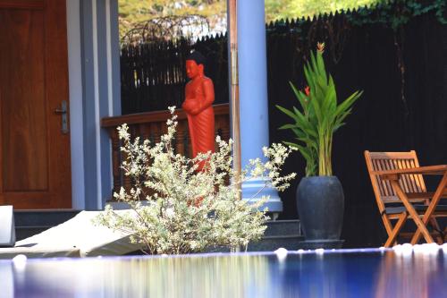 a man standing on the porch of a house at Villa b.Maison d'Hôtes Angkor in Siem Reap