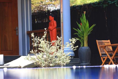 un hombre parado en el porche de una casa en Villa b.Maison d'Hôtes Angkor en Siem Riep