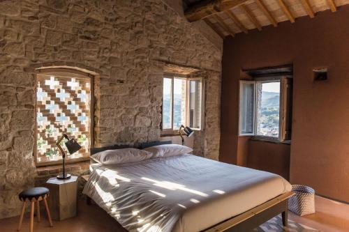 ein Schlafzimmer mit einem Bett in einer Steinmauer in der Unterkunft Villa Fortezza Antique Rooms in Ascoli Piceno