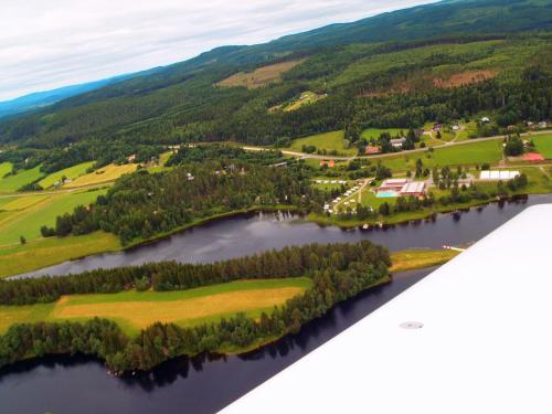 an aerial view of a lake with trees and houses at Stöde Camping in Edsta
