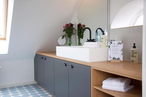 a bathroom counter with a sink and a mirror at Lieblingsplatz Strandhotel in Sankt Peter-Ording