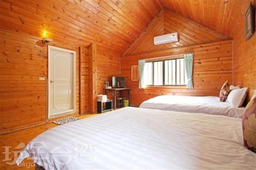 a bedroom with two beds in a wooden cabin at Double Lake B&B in Zhushan