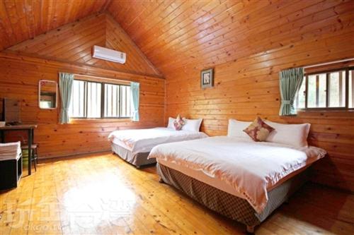 sypialnia z 2 łóżkami w drewnianym domku w obiekcie Double Lake B&B w mieście Zhushan