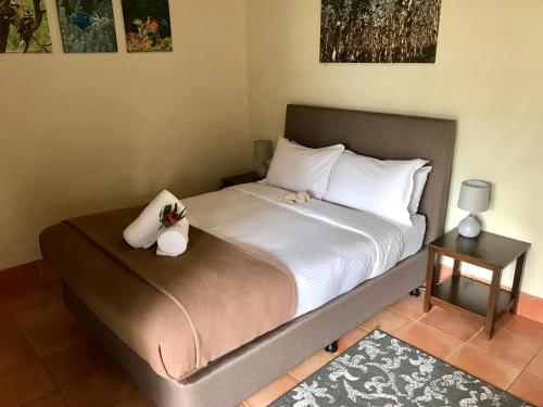 a bedroom with a bed with white sheets and pillows at Happy Dogs Cottage Margaret River in Margaret River Town