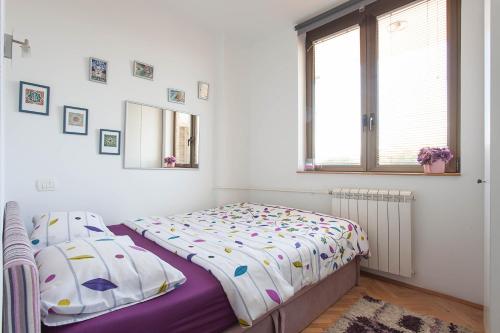 a bedroom with a bed and a window at VIOLET APARTMENT in Skopje