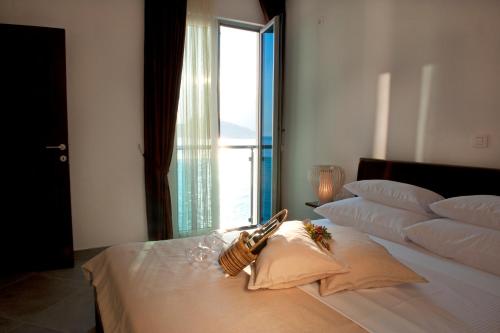 a bedroom with a large bed with a window at Love Live Hotel in Sutomore