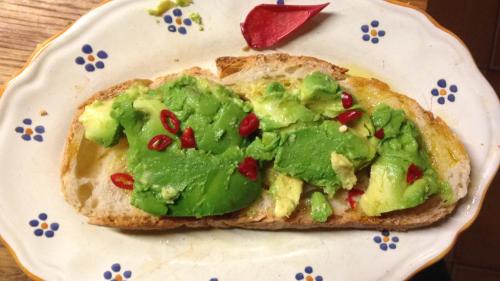 un pezzo di pane con avocado e melograni su un piatto di Villa Fortezza Antique Rooms ad Ascoli Piceno