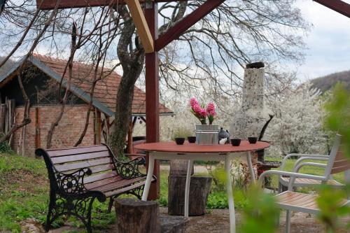 a table and a bench and a table with flowers at Na Okić - a private forest oasis in Sveti Martin pod Okićem