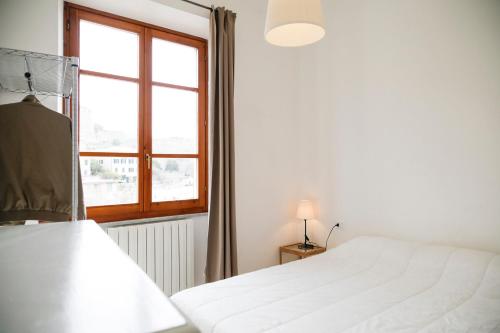 ポルトフェッラーイオにあるAppartamento Ponticello by HelloElbaのベッドルーム(白いベッド1台、窓付)