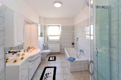 ein Bad mit einer Badewanne, einem Waschbecken und einer Dusche in der Unterkunft Haus Gerrie in Mauth