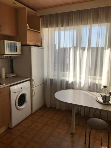 a small kitchen with a table and a washing machine at Viru pst 20 in Sillamäe