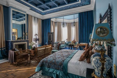 a bedroom with a king sized bed and a living room at Palais Ronsard Relais & Chateaux in Marrakesh