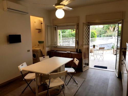 a dining room with a table and chairs and a patio at La casa dei sassi holiday house in Giardini Naxos