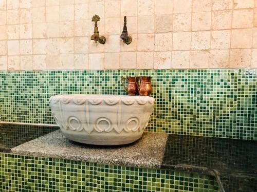 a green tiled bathroom with a white bowl on a counter at Kale Lodge - Adult Only + 15 in Kas