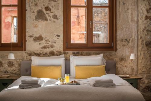 a bedroom with a large bed with yellow pillows at Residenza Vranas Boutique Hotel in Chania Town