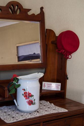 a white vase sitting on a table in front of a mirror at Obelix Guesthouse in Lüderitz