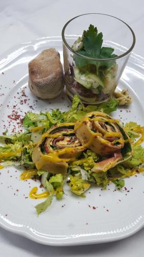 a white plate with a salad and a bowl of food at Hotel Wippertal - voll klimatisiert in Bernburg