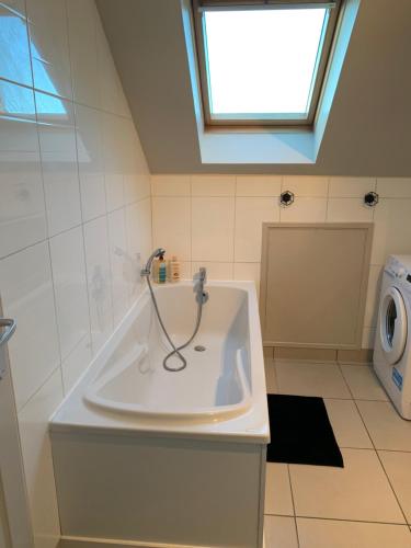 La salle de bains est pourvue d'une baignoire et d'une douche. dans l'établissement Appartement de 70 m2 bien situé à Boulogne sur mer, à Boulogne-sur-Mer