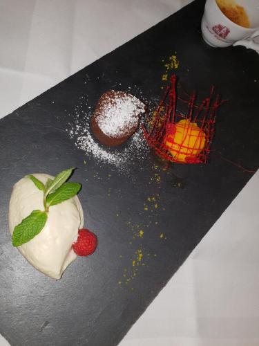 a plate with a dessert with a strawberry and powdered sugar at Hotel Wippertal - voll klimatisiert in Bernburg