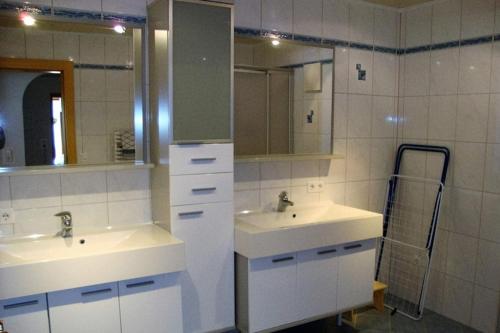 een badkamer met 2 wastafels en een spiegel bij Appartements Schwoagerhof in Fügen