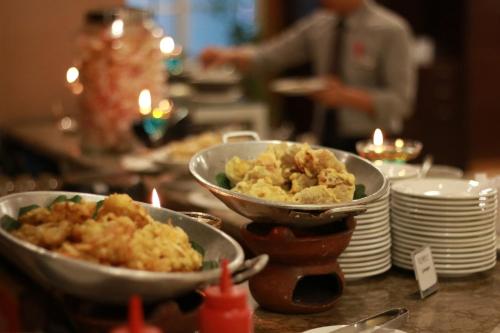 two bowls of food on a table with plates at Serela Riau by KAGUM Hotels in Bandung