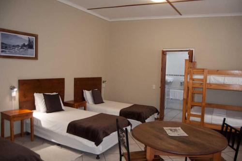 a hotel room with two beds and a table at Obelix Guesthouse in Lüderitz