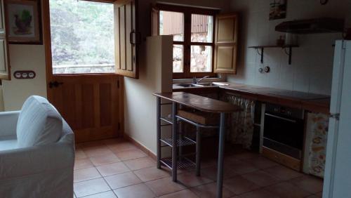 uma cozinha com um balcão, um lavatório e uma mesa em La Forna del Coto em Coto de Buenamadre