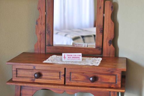 a wooden dresser with a mirror on top of it at Obelix Guesthouse in Lüderitz