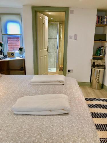 two beds with white towels on them in a room at Kwetu Cabin in Bordon