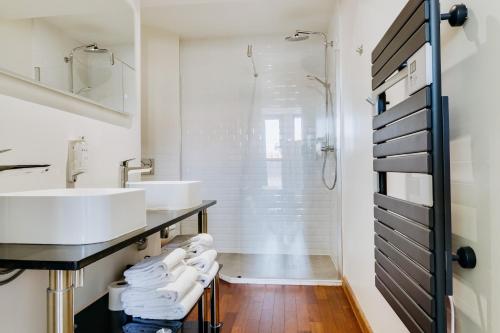 a bathroom with two sinks and a shower at IKO Bordeaux Appartements in Bordeaux