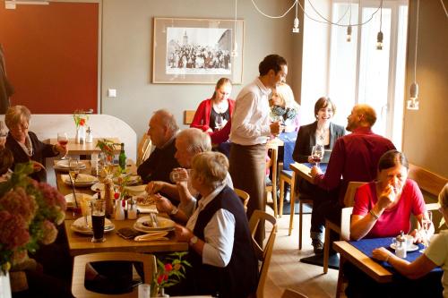 a group of people sitting at tables in a restaurant at Familienhotel Weimar mit Ferienwohnungen in Weimar