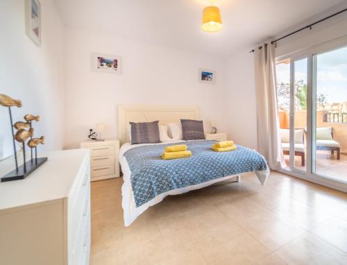 a bedroom with a bed with yellow pillows on it at Apartment La Loma Mar Menor Golf Resort in Los Martínez