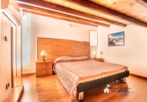 a bedroom with a large bed and a wooden headboard at AKRAI in Palazzolo Acreide