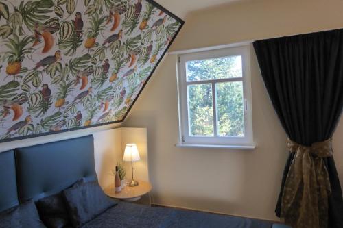 um quarto com uma janela e um mural de pássaros em Casa Carina Ferienhaus, Oberwohnung mit kleinem Sonnenbalkon und Terrasse em Süderschweiburg