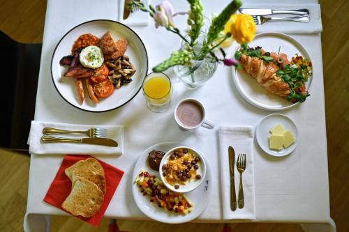 a white table with plates of food on it at Wellness Hotel Vista in Dolní Morava