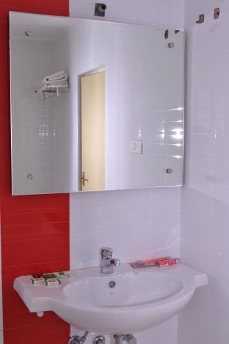 a bathroom with a white sink and a mirror at Hotel Susee Park in Tiruchchirāppalli