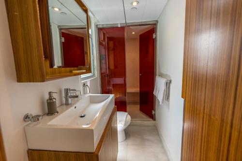 um banheiro com uma pia, um vaso sanitário e um espelho em Homy Residence em Hong Kong