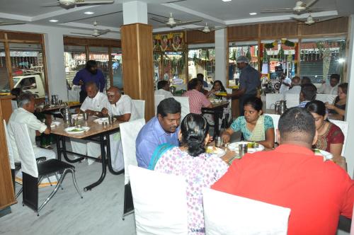 a group of people sitting at tables in a restaurant at Hotel Susee Park in Tiruchchirāppalli