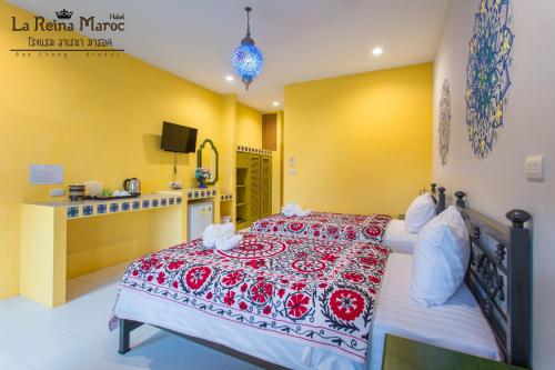 a bedroom with a bed with a red and white bedspread at La Reina Maroc Hotel ปากช่อง เขาใหญ่ in Pak Chong