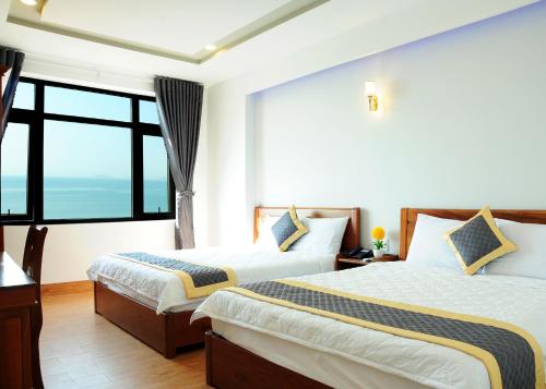 a hotel room with two beds and a large window at SEASIDE HOTEL in Quy Nhon