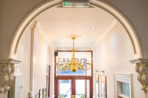 an archway in a hallway with a chandelier at London Town Hotel in London