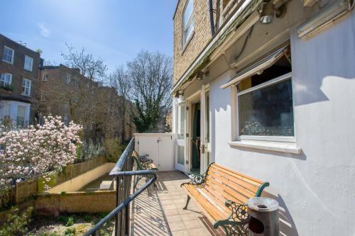 a wooden bench sitting on the porch of a house at London Town Hotel in London