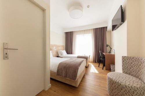 a hotel room with a bed and a desk at Hotel Porto Mar in Matosinhos