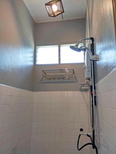 a bathroom with a shower with a window at The Hidden Gems in Pantai Cenang
